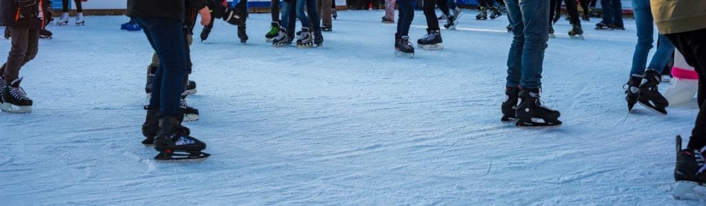 Menschen mit Schlittschuhen auf mobiler Eisbahn