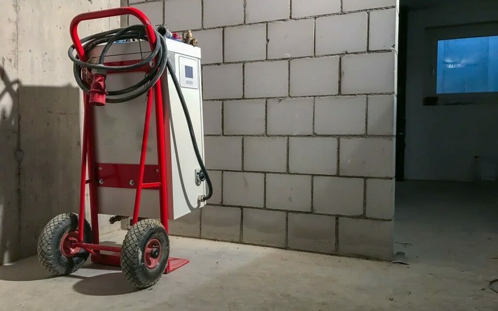 Mobiles Elektroheizmobil montiert auf rotem Fahrgestell im Keller eines Hauses